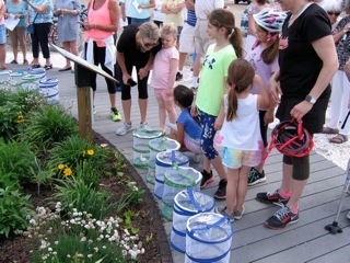 A group of children gathered around a large bucket